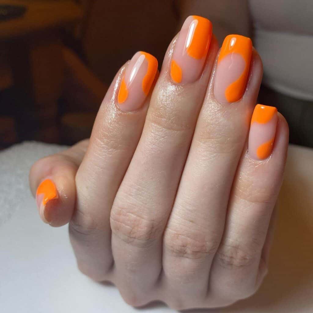 Chic summer nails featuring vibrant orange hues, from neon to burnt with glitter accents, perfect for adding a seasonal touch.